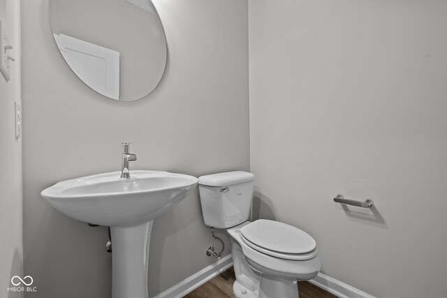 bathroom with hardwood / wood-style flooring and toilet