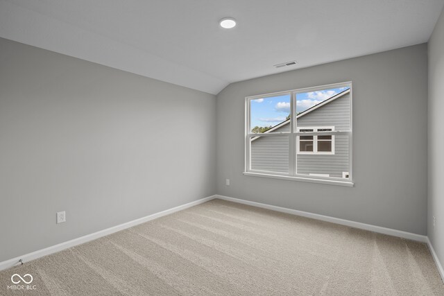 carpeted spare room featuring lofted ceiling