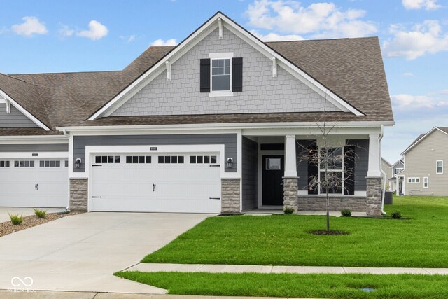 craftsman-style house with a garage and a front lawn