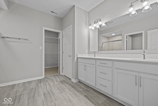 bathroom featuring a shower with door and vanity