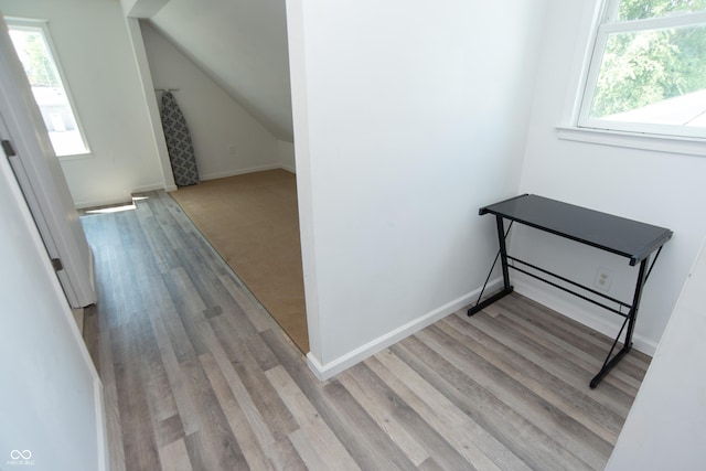 staircase with wood-type flooring, plenty of natural light, and lofted ceiling