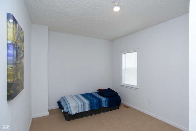 bedroom featuring a textured ceiling and carpet