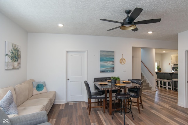 dining room featuring ceiling fan, dark hardwood / wood-style flooring, and a textured ceiling