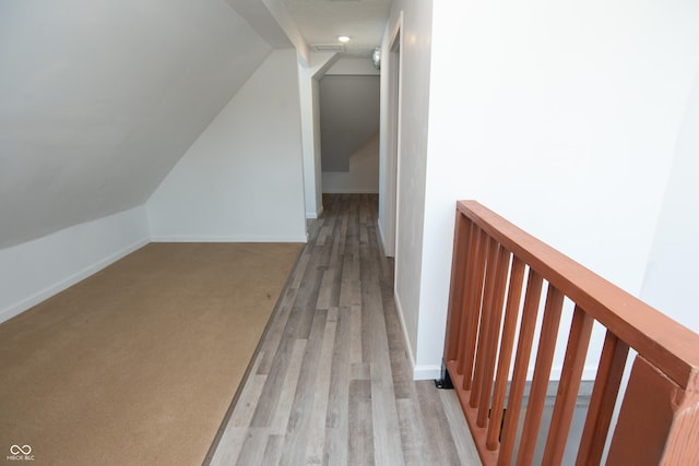 additional living space featuring lofted ceiling and light hardwood / wood-style flooring