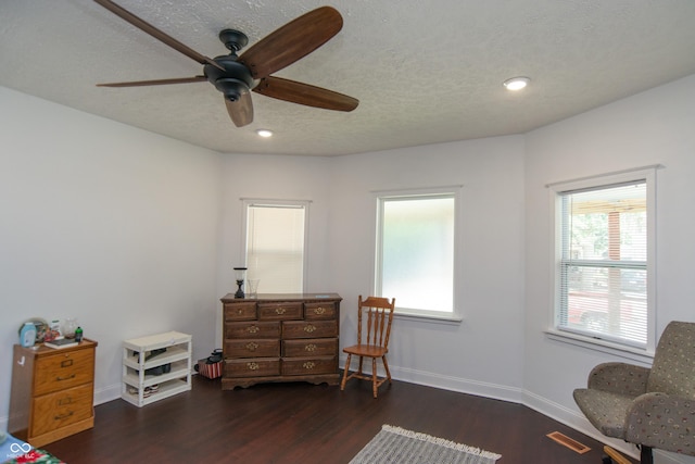 sitting room with dark hardwood / wood-style flooring, ceiling fan, and a textured ceiling