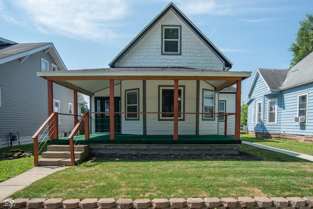 view of front of home with cooling unit, a front yard, and covered porch