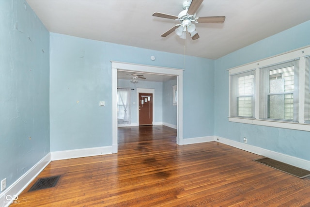 empty room featuring dark wood-type flooring and ceiling fan