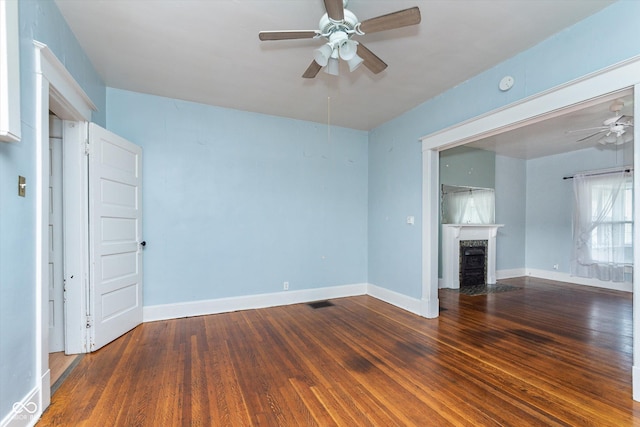 unfurnished living room featuring ceiling fan and dark hardwood / wood-style flooring