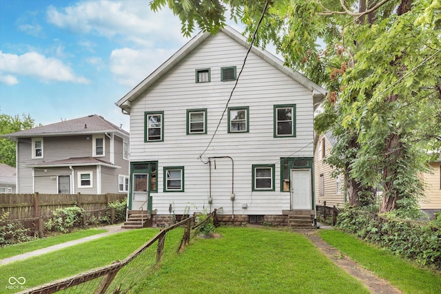 rear view of house featuring a yard