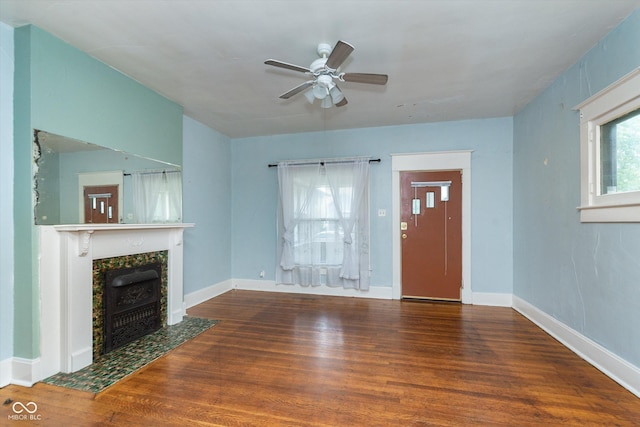 unfurnished living room with ceiling fan, a fireplace, a wealth of natural light, and hardwood / wood-style floors