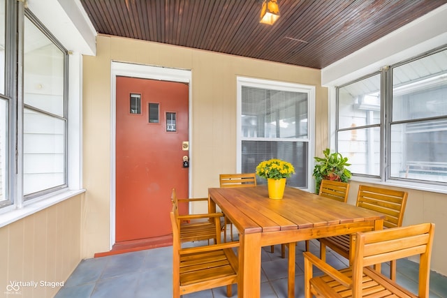 dining space featuring wooden walls and wooden ceiling