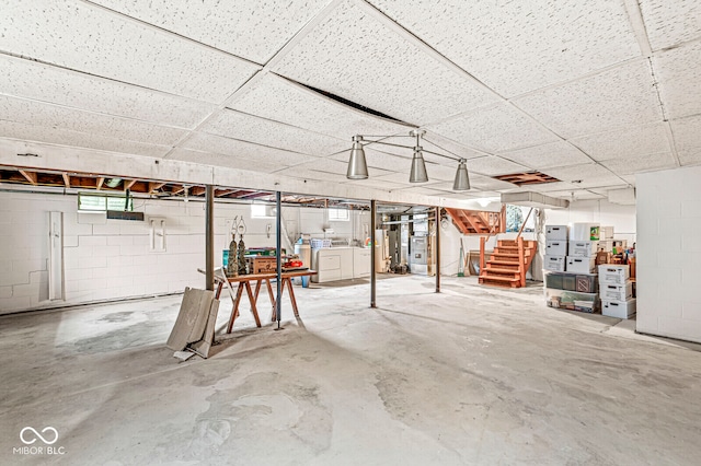 basement with washer / dryer, a paneled ceiling, and heating unit