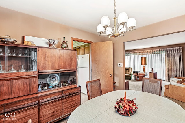 dining area featuring a notable chandelier and carpet floors