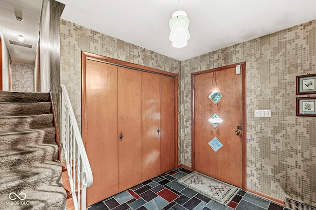 entryway with dark tile patterned floors