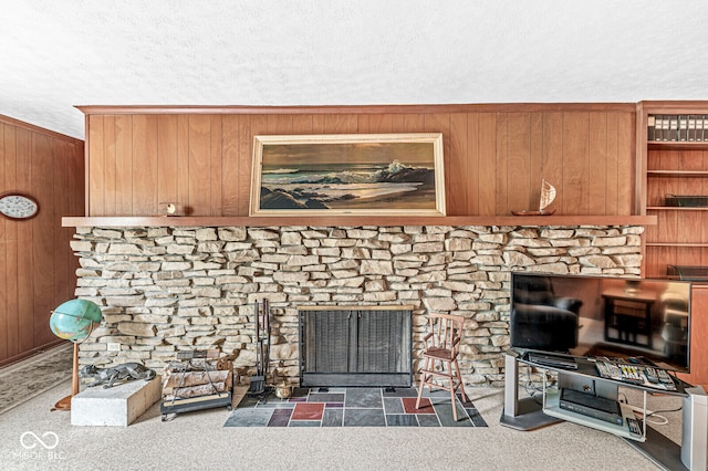 details featuring a fireplace, wood walls, a textured ceiling, and carpet flooring