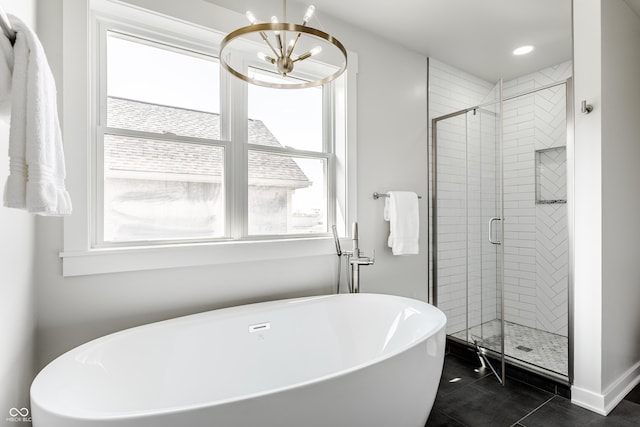 bathroom featuring baseboards, a soaking tub, tile patterned floors, a stall shower, and an inviting chandelier