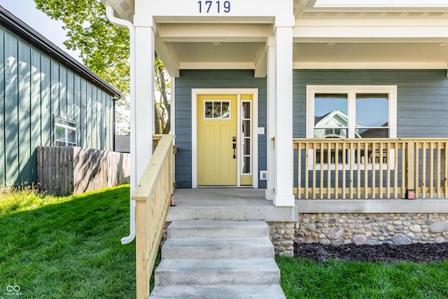 entrance to property with a yard and a porch