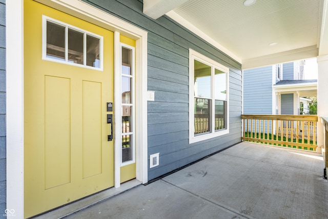 view of exterior entry featuring covered porch