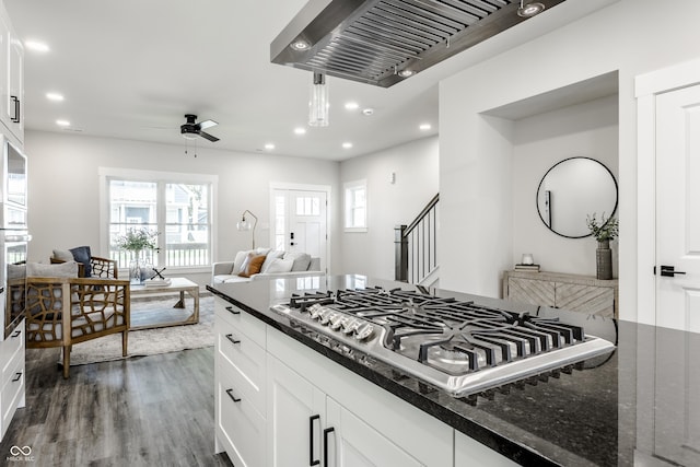 kitchen featuring dark stone counters, open floor plan, white cabinetry, and stainless steel gas stovetop