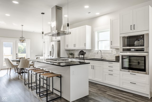 kitchen featuring appliances with stainless steel finishes, dark countertops, a sink, and extractor fan