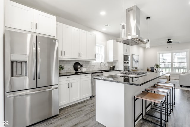 kitchen featuring stainless steel appliances, white cabinetry, a kitchen island, and island range hood