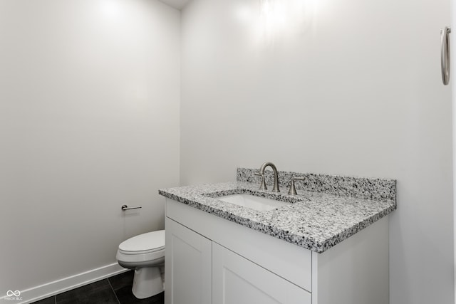 bathroom with toilet, tile patterned flooring, vanity, and baseboards