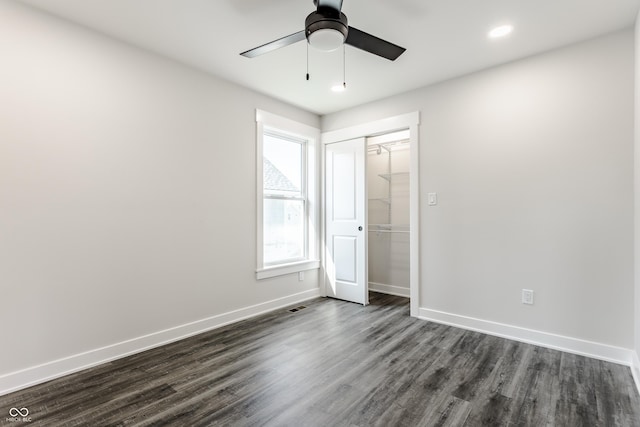 unfurnished bedroom featuring a ceiling fan, a closet, baseboards, and dark wood-type flooring