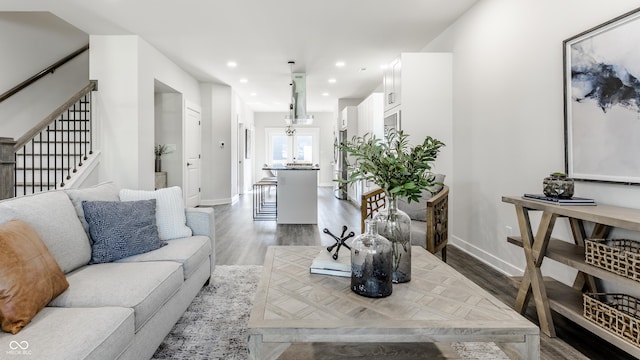 living area with baseboards, stairway, wood finished floors, and recessed lighting