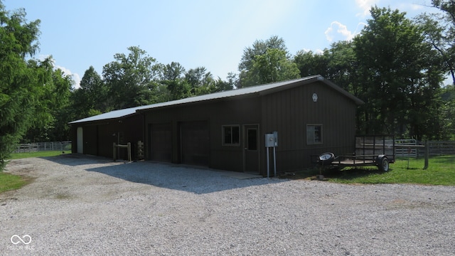 view of front of house featuring a garage and an outbuilding