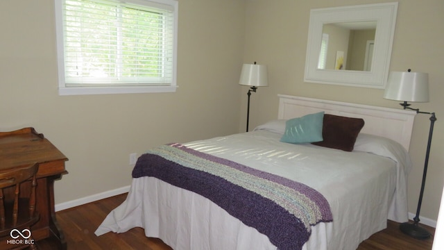 bedroom with dark hardwood / wood-style floors