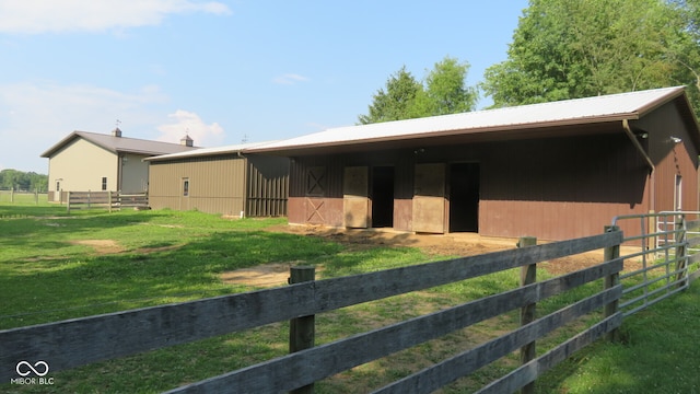 view of stable with an outbuilding and a lawn