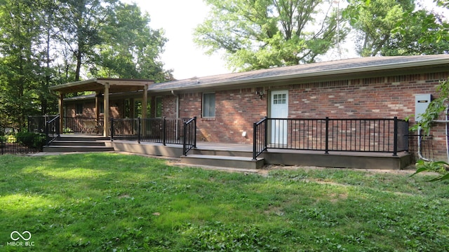 rear view of property featuring a wooden deck and a lawn