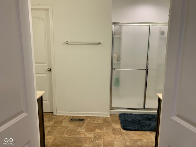 bathroom with vanity and a shower with shower door