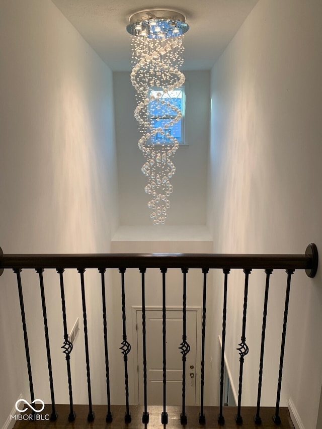 stairs with a notable chandelier