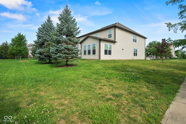 rear view of house featuring a yard