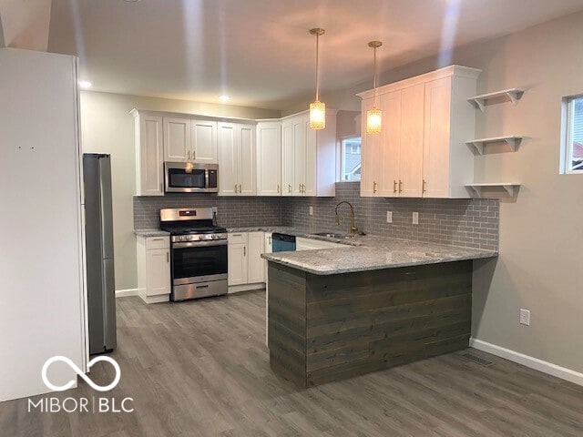 kitchen featuring wood-type flooring, stainless steel appliances, and white cabinets