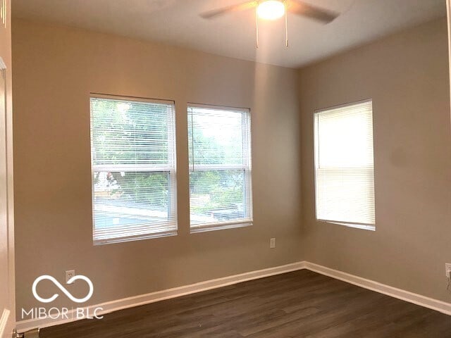 unfurnished room featuring dark hardwood / wood-style floors and ceiling fan