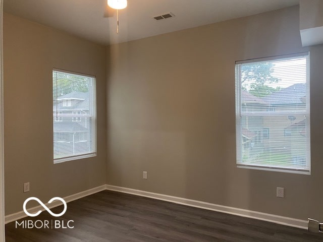 spare room featuring dark hardwood / wood-style flooring, a healthy amount of sunlight, and ceiling fan