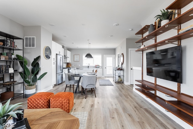 living room with sink and light hardwood / wood-style floors