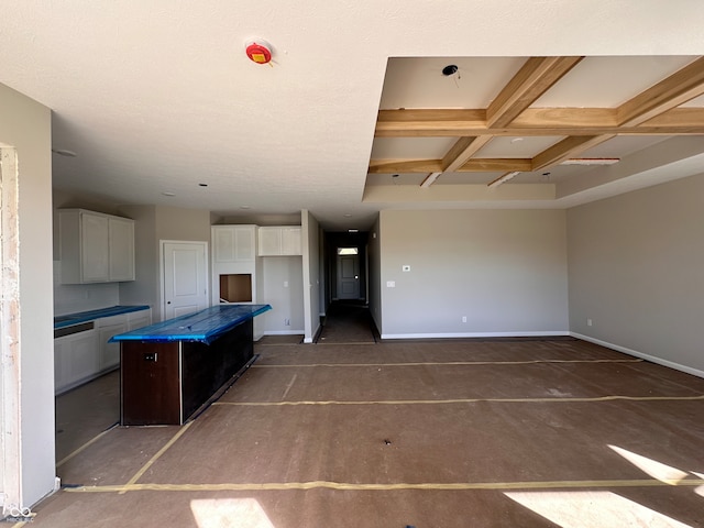 kitchen with white cabinets, beam ceiling, a kitchen island, and coffered ceiling