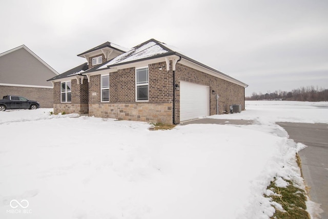 view of front of house with central AC and a garage