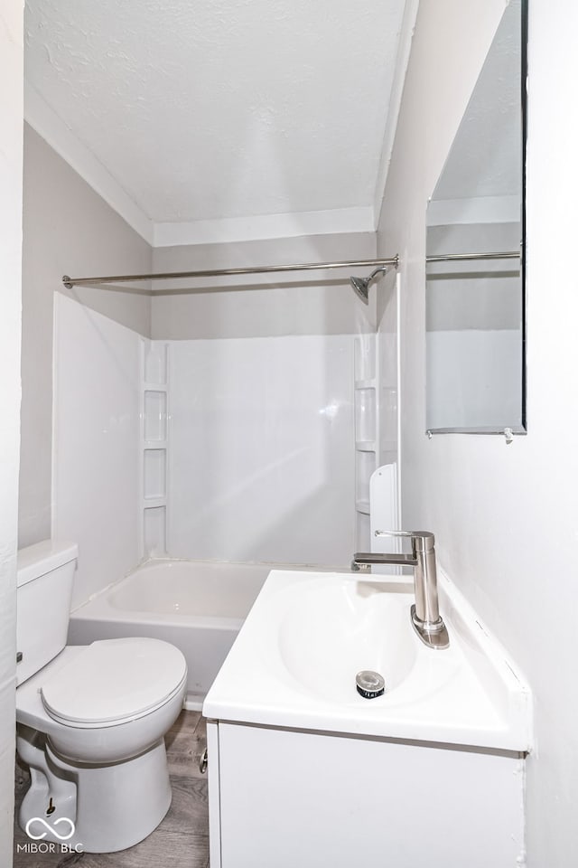 full bathroom featuring toilet, hardwood / wood-style floors, washtub / shower combination, crown molding, and vanity