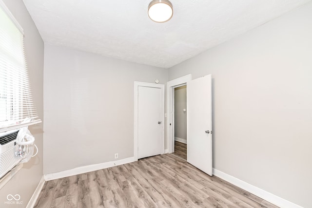 unfurnished bedroom with multiple windows and light wood-type flooring