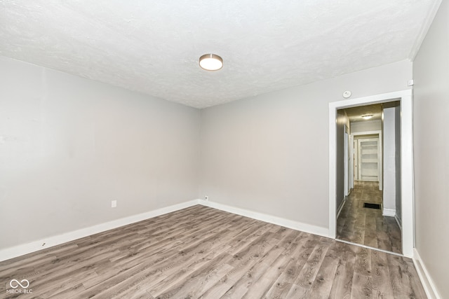 empty room featuring a textured ceiling and wood-type flooring