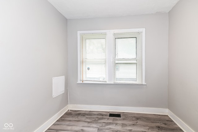 spare room featuring hardwood / wood-style flooring and plenty of natural light