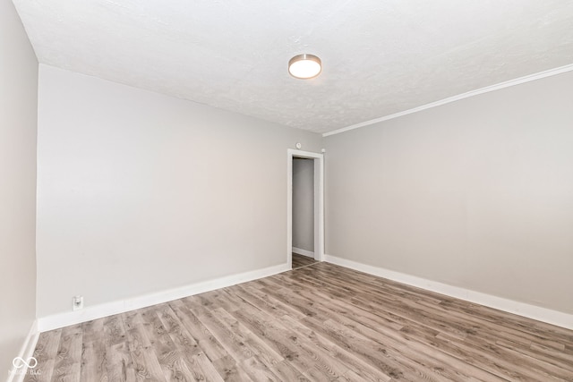 empty room with a textured ceiling and wood-type flooring