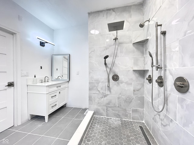 bathroom featuring vanity, tile patterned floors, and a tile shower