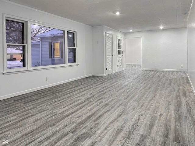 empty room featuring ornamental molding and hardwood / wood-style floors