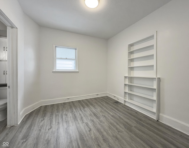 spare room featuring a textured ceiling and dark wood-type flooring