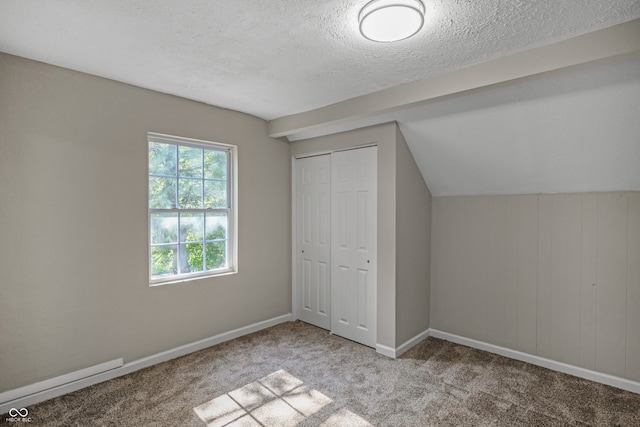 unfurnished bedroom with carpet floors, a textured ceiling, a closet, and lofted ceiling